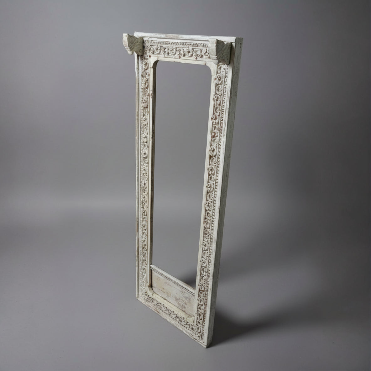 Ashva Wooden Mirror Frame in white with intricate carved wooden details, showcasing elegant handicraft decor ideal for adding a rustic, artistic touch to any space.