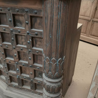 Handcrafted wooden cabinet with detailed carved post and rustic metal accents