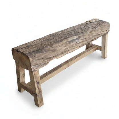 Rustic wooden bench handcrafted with a solid timber slab seat, showcasing natural grain and texture, supported by sturdy wooden legs for authentic tribal handicraft decor.
