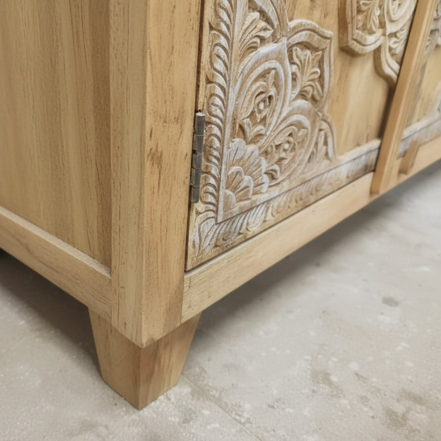 Hand-carved wooden cabinet corner with intricate tribal floral patterns