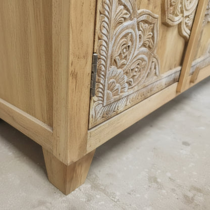 Hand-carved wooden cabinet corner with intricate tribal floral patterns