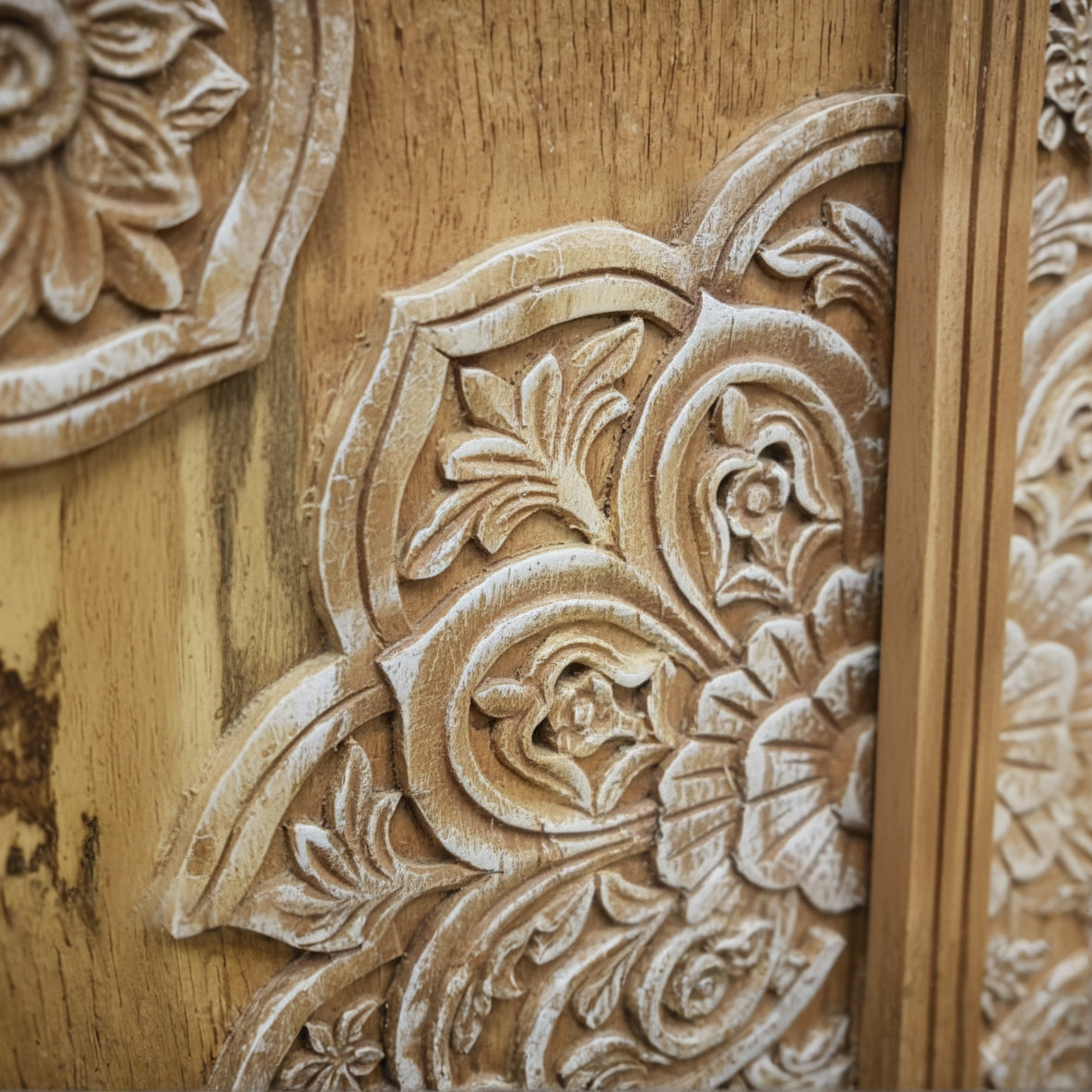 Detailed hand-carved wood panel with floral tribal patterns, natural finish