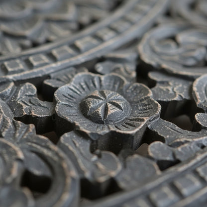 Close-up of intricate black wood floral carving, traditional handmade tribal decor