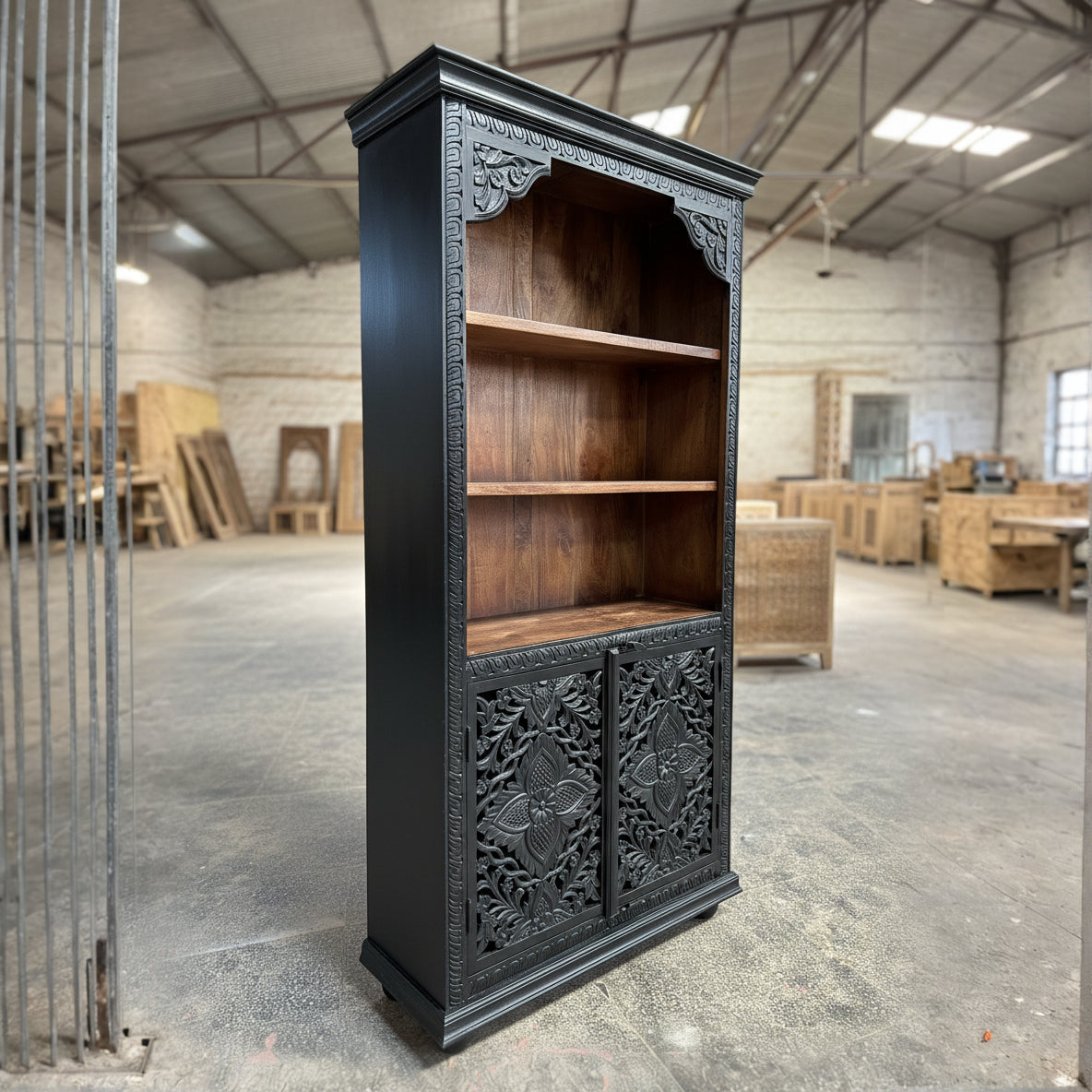 Handcrafted wooden bookshelf with ornate carved doors in rustic warehouse setting