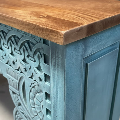 Close-up of the carved wooden side and natural wood top of the Rani Carved Console Unit, showcasing detailed craftsmanship and textured blue finish.